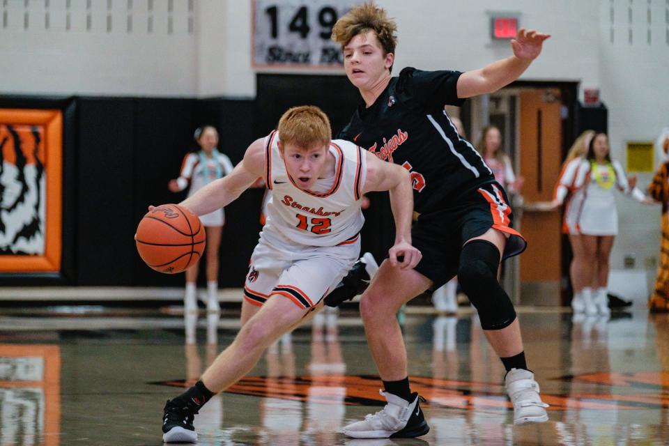 Strasburg's Dylan Walker dribbles past Newcomerstown's David Newkirk during their game in Strasburg, Tuesday, Nov. 30, 2021.