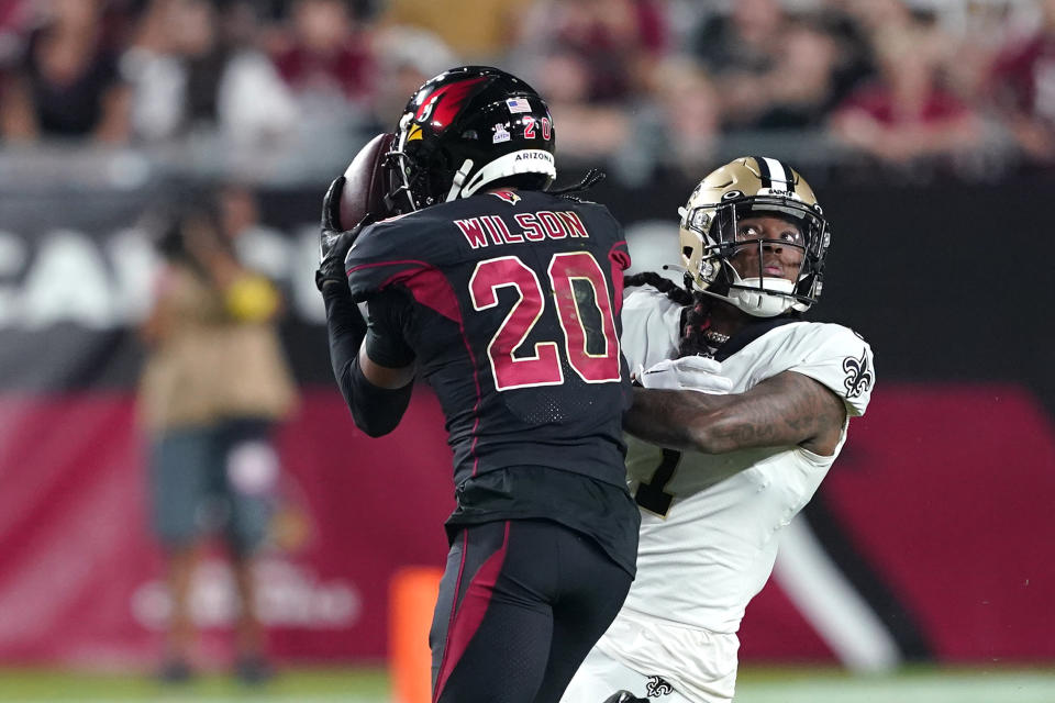 Arizona Cardinals cornerback Marco Wilson (20) intercepts a pass intended for New Orleans Saints wide receiver Marquez Callaway, facing camera, which he returned for a touchdown, during the first half of an NFL football game, Thursday, Oct. 20, 2022, in Glendale, Ariz. (AP Photo/Matt York)