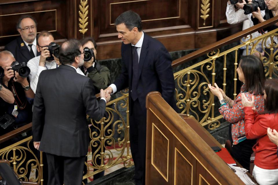 TOPSHOT - Spanish out-going Prime Minister Mariano Rajoy (L) shakes hands with Spain's new Prime Minister Pedro Sanchez after a vote on a no-confidence motion at the Lower House of the Spanish Parliament in Madrid on June 01, 2018. - Spain's parliament ousted on June 1, 2018 Prime Minister Mariano Rajoy in a no-confidence vote sparked by fury over his party's corruption woes, with his Socialist arch-rival Pedro Sanchez automatically taking over. (Photo by Emilio Naranjo / POOL / AFP)        (Photo credit should read EMILIO NARANJO/AFP/Getty Images)