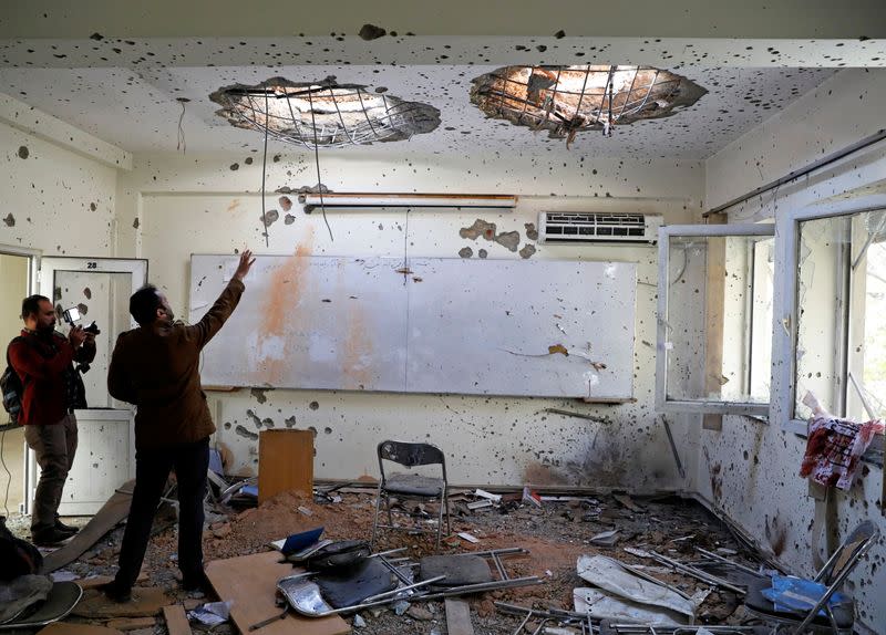 Afghan journalists film inside a classroom after yesterday's attack at the university of Kabul
