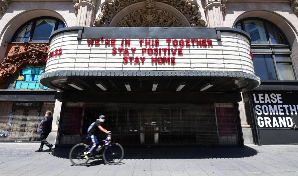 <span class="caption">In Los Angeles, California, the Million Dollar Theater, closed due to the pandemic, offers some comforting words on its marquee.</span> <span class="attribution"><a class="link " href="https://www.gettyimages.com/detail/news-photo/cyclist-in-facemask-rides-past-the-million-dollar-theater-news-photo/1211761309?adppopup=true" rel="nofollow noopener" target="_blank" data-ylk="slk:Getty Images / Frederic J. Brown;elm:context_link;itc:0;sec:content-canvas">Getty Images / Frederic J. Brown</a></span>