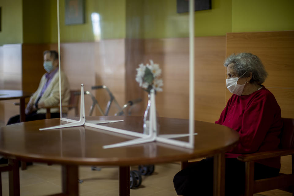 Residents wait the visit of their families through a glass for protecting against COVID-19 at DomusVi nursing home in Leganes, Spain, Wednesday, March 10, 2021. Spain is preparing to tighten some pandemic restrictions on movement during the approaching Easter holiday, which is a traditional period for family visits. (AP Photo/Manu Fernandez)