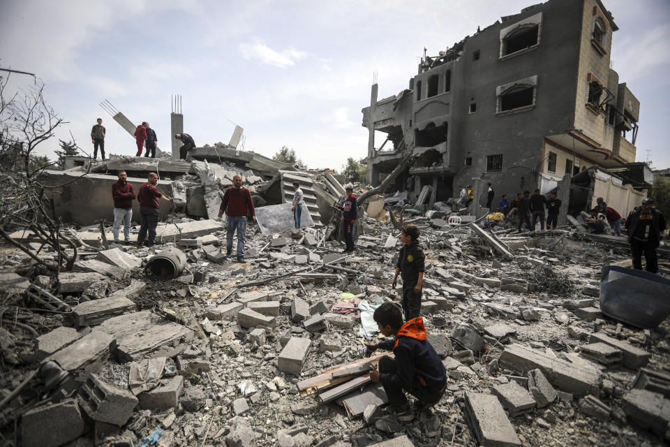 Palestinians inspect the damage to a residential building for the Moussa family after an Israeli airstrike in the Maghazi refugee camp, central Gaza Strip, Friday, March 29, 2024. (AP Photo/Ismael Abu Dayyah)