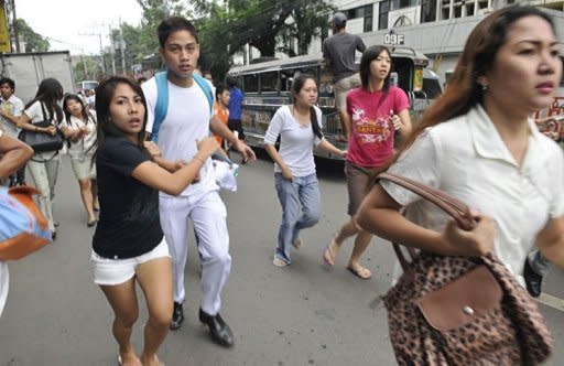 Residents run to safety after a 6.8 earthquake hit Cebu City. Rescuers in the Philippines dug through rubble with shovels and their bare hands Tuesday after a powerful earthquake triggered landslides, collapsed homes and killed dozens of people