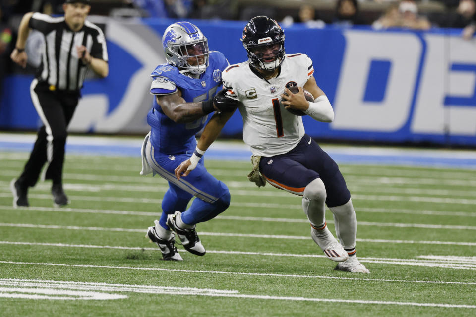 Chicago Bears quarterback Justin Fields (1) pulls away from a Detroit Lions defender during the second half of an NFL football game, Sunday, Nov. 19, 2023, in Detroit. (AP Photo/Duane Burleson)