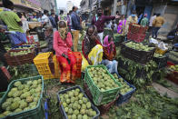Fruit vendors cover their faces as a precaution against the coronavirus and wait for buyers at a wholesale market in Bengaluru, India, Thursday, Sept. 24, 2020. In the April-June quarter, government figures show, activity in trade, hotels, transport, construction and communication declined by nearly half from a year earlier. Manufacturing contracted by about 40%. Despite the strains, there are some bright spots. Agriculture overall is growing at a 3.4% pace. With good monsoon rains, India might attain a record of 301 million metric tons of food-grain output, including wheat, rice, oil seeds, lentils and mustard, in the 2020-21 financial year, 4 million metric tons more than in 2019-20. (AP Photo/Aijaz Rahi)