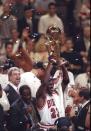 Michael Jordan hoists the championship trophy after the Bulls beat the Utah Jazz in Game 6 of the 1997 NBA Finals. (Getty Images)