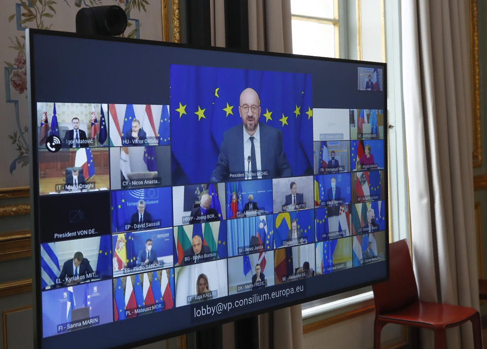 FILE - In this March 25, 2021, file photo, European Council President Charles Michel shown on a screen, center, speaks during a video conference of a EU summit projected at the Elysee Palace in Paris. European Union leaders no longer meet around a common oval summit table to broker their famed compromises. Instead, each of the 27 watches the others with suspicion via a video screen that shows a mosaic of faraway capitals. (AP Photo/Michel Euler, Pool, File)