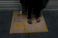 A mentally ill homeless man stands on a piece of cardboard on a sidewalk in Los Angeles, Friday, April 15, 2022. A controversial bill signed by Gov. Gavin Newsom could improve that by forcing people suffering from severe mental illness into treatment. But they need to be diagnosed with a certain disorder such as schizophrenia and addiction alone doesn't qualify. (AP Photo/Jae C. Hong)