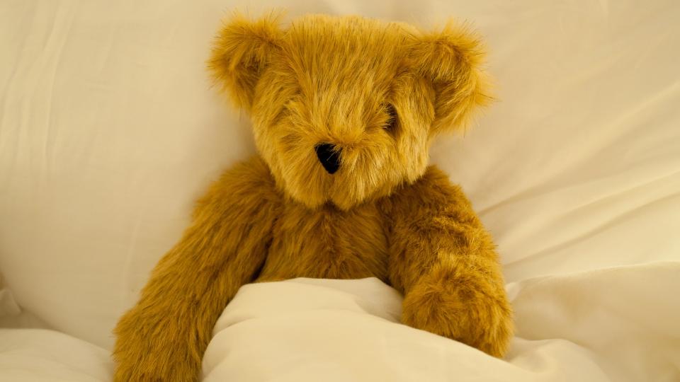 teddy bear tucked in bed