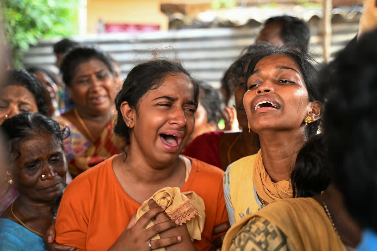 Relatives mourn the people who died after consuming toxic illegal alcohol in Kallakurichi in India’s Tamil Nadu state on 20 June 2024 (AFP via Getty)