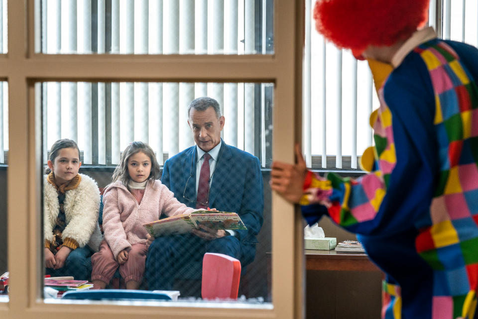 (l to r) Luna (Christiana Montoya), Abbie (Alessandra Perez), and Otto (Tom Hanks) are entertained by a clown as they wait in Columbia Pictures A MAN CALLED OTTO.  Photo by: Niko Tavernise