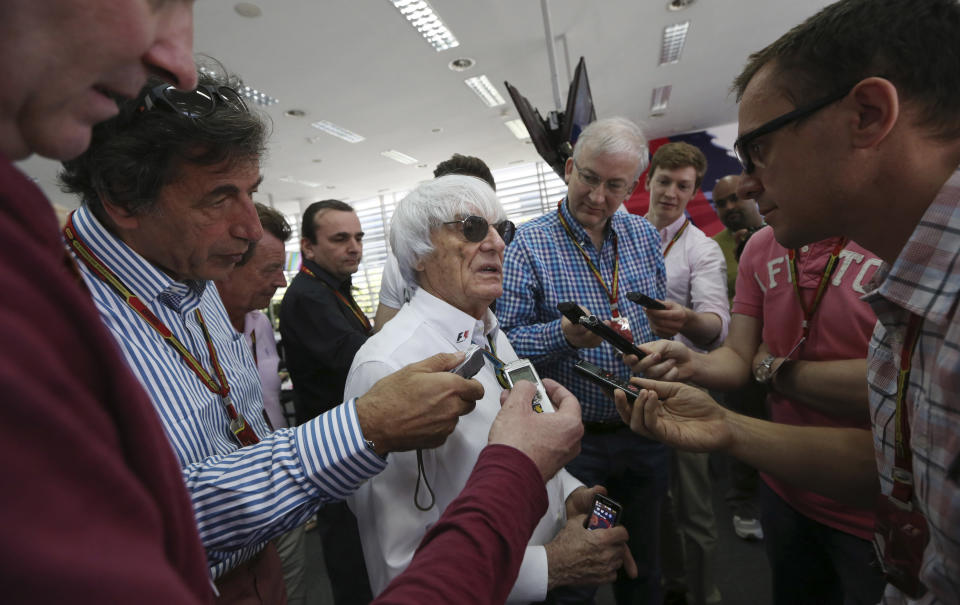 Bernie Ecclestone, center, president and CEO of Formula One Management, center, answers to reporters in the newsroom ahead the the Bahrain Formula One Grand Prix at the Bahrain International Circuit in Sakhir, Bahrain, Sunday, April 6, 2014. (AP Photo/Luca Bruno)