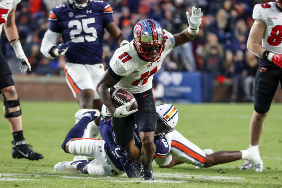 Western Kentucky wide receiver Malachi Corley (11) carries the ball as Auburn cornerback Keionte Scott (6) tackles him during the first half of an NCAA college football game Saturday, Nov. 19, 2022, in Auburn, Ala. (AP Photo/Butch Dill)