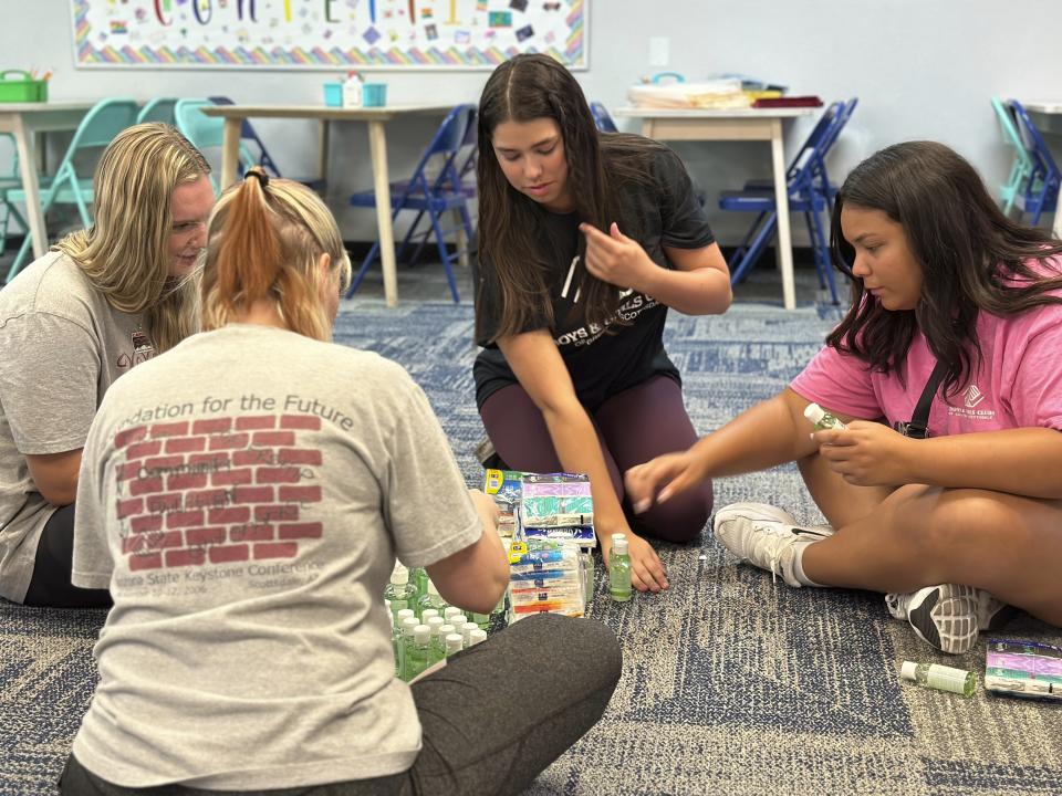 Addison Beer, 17, second from right, and Jaylin Wilson, 18, right, prepares for summer campers arriving next week at the Virginia G. Piper branch of the Boys & Girls Club where she works, Thursday, May, 25, 2023 in Scottsdale, Ariz. With the job market the tightest in half a century, younger workers are playing a critical role in kicking off the summer tourism season this Memorial Day weekend. (AP Photo/Alina Hartounian)