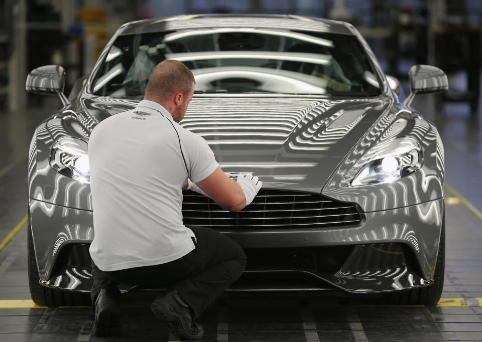 GAYDON, ENGLAND - JANUARY 10:  An Aston Martin Vanquish is inspected by hand inside a light booth at the company headquarters and production plant on January 10, 2013 in Gaydon, England. The iconic British brand is celebrating its 100th anniversary. Lionel Martin and Robert Bamford created Bamford & Martin on January 15 1913, which later became Aston Martin in honour of Bamford’s wins at the Aston Clinton Hillclimb in Buckinghamshire.  (Photo by Christopher Furlong/Getty Images)