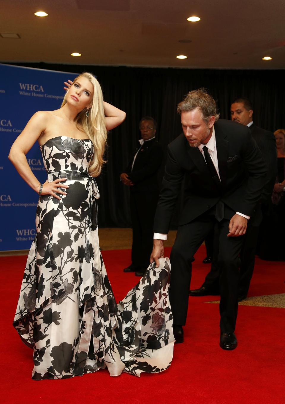 Actress Jessica Simpson is helped with her dress by actor Eric Johnson as they arrive on the red carpet at the annual White House Correspondents' Association Dinner in Washington, May 3, 2014. (REUTERS/Jonathan Ernst)