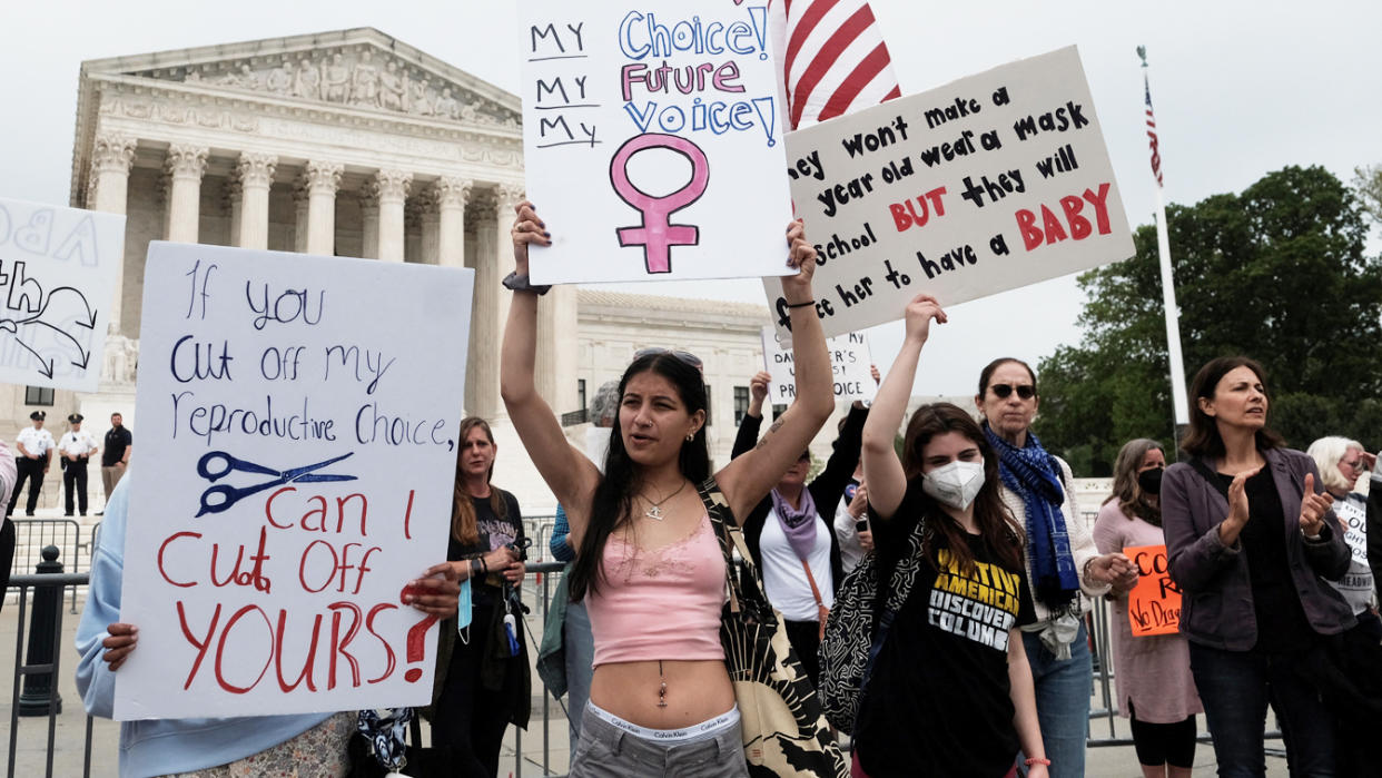 Demonstrators protest in front of the U.S. Supreme Court building with signs reading: If you cut off my reproductive choice, I can cut off yours; My choice, my future, my voice; and others.