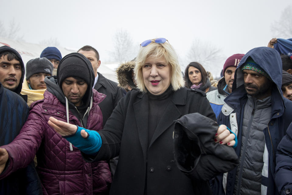 Dunja Mijatovic, the Council of Europe Commissioner for Human Rights, talks to a group of migrants at the Vucjak refugee camp outside Bihac, northwestern Bosnia, Tuesday, Dec. 3, 2019. Mijatovic has demanded immediate closure of the migrant camp where hundreds of people have started refusing food and water to protest dismal living conditions as wintry weather sets in. (AP Photo/Darko Bandic)