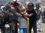 Opposition supporters help a protester during a rally against Venezuela's President Nicolas Maduro in Caracas, Venezuela, April 26, 2017. REUTERS/Marco Bello