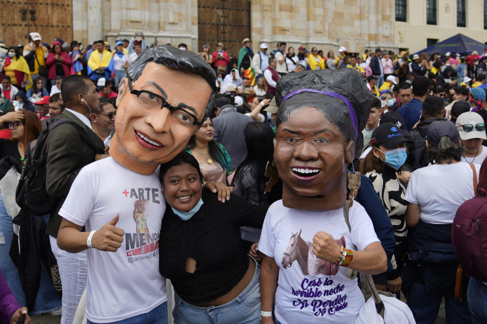 Partidarios del nuevo presidente Gustavo Petro, con máscaras de él y de la nueva vicepresidenta Francia Márquez, a la derecha, esperan la ceremonia de juramentación en la plaza de Bolívar en Bogotá, Colombia, el domingo 7 de agosto de 2022. (AP Foto/Ariana Cubillos)