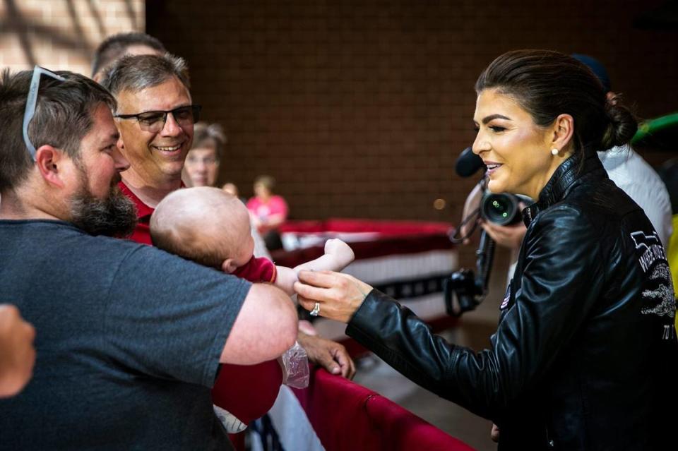 Casey DeSantis, wife of Florida governor and presidential candidate Ron DeSantis, greets Mike Williams and his 3-month-old son Sawyer during the annual Roast and Ride fundraiser for U.S. Sen. Joni Ernst, Saturday, June 3, 2023, at the Iowa State Fairgrounds in Des Moines, Iowa.