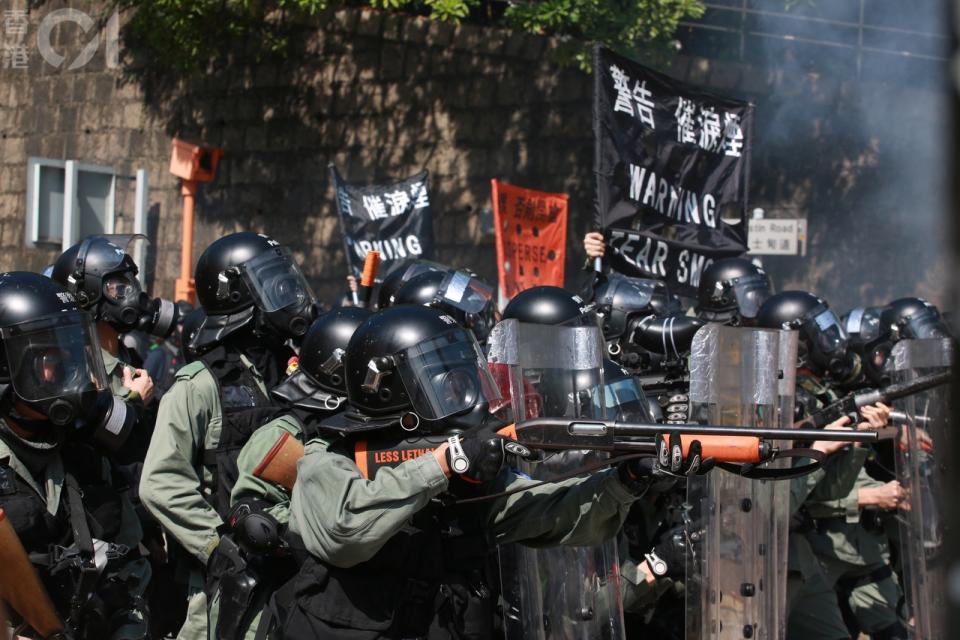 ▲香港警察於理工大學外，舉旗警示並持槍驅離示威者。（圖／翻攝自《香港 01 》／羅國輝攝）
