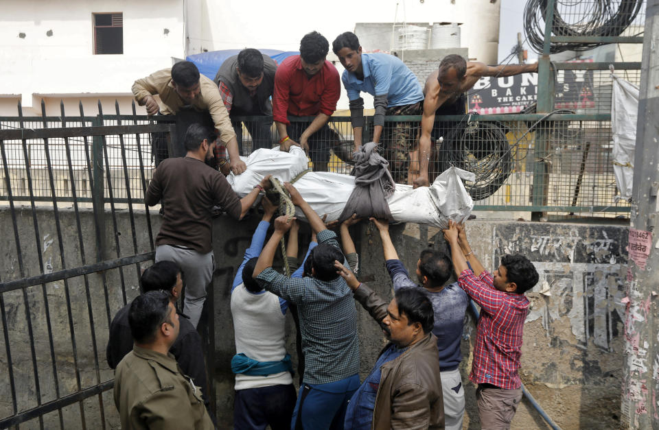 Poeple carry the body of an unidentified man after retrieving it from an open drain in a riot affected area after clashes erupted between people demonstrating for and against a new citizenship law in New Delhi, India, February 26, 2020. REUTERS/Adnan Abidi