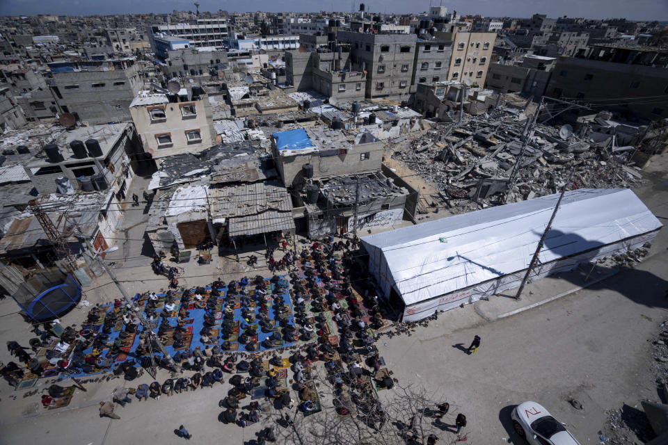 Palestinians perform the first Friday prayers of the Muslim holy month of Ramadan near the ruins of a destroyed mosque by the Israeli airstrikes in Rafah, Gaza Strip, Friday, March 15, 2024. (AP Photo/Fatima Shbair)