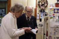 In this Tuesday, Oct. 30, 2012 photo, Dr. Russell Dohner, right, talks with nurse Rose Busby about a patient's prescription in Rushville, Ill. In an era of rising healthcare costs, the 87-year-old doctor only charges patients $5 per office visit and doesn't take insurance saying it isn't worth the bother. (AP Photo/Jeff Roberson)