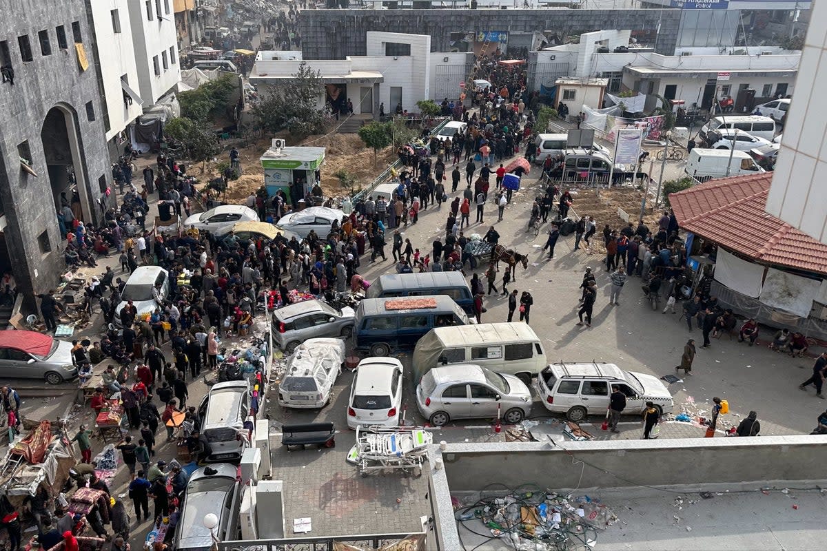 Displaced Palestinians gather in the yard of Gaza’s Al-Shifa Hospital on 10 December (AFP via Getty Images)