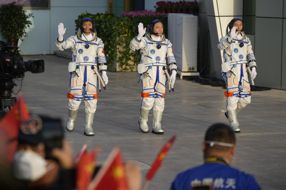 Chinese astronauts for the Shenzhou-16 mission, from left, Gui Haichao, Jing Haipeng and Zhu Yangzhu wave as they arrive for a send-off ceremony ahead of their manned space mission at the Jiuquan Satellite Launch Center in northwestern China, Tuesday, May 30, 2023. (AP Photo/Mark Schiefelbein)