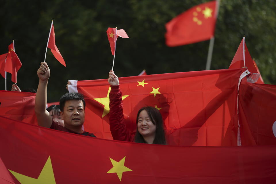 FILE - In this Aug. 17, 2019, file photo, pro-China counter-protesters hold Chinese flags during an anti-extradition rally for Hong Kong in Vancouver. Governments around the world are taking a cautious approach to responding to the protests roiling Hong Kong. With the notable exception of Taiwan, cautious comments from a handful of governments fall short of support for the demonstrators. They are so mild that even the word “protest” itself was left out of the joint EU-Canada statement that was the most recent to infuriate the Chinese government. Most are unwilling to risk that fury at all, showing China’s deep influence around the world. (Darryl Dyck/The Canadian Press via AP, File)