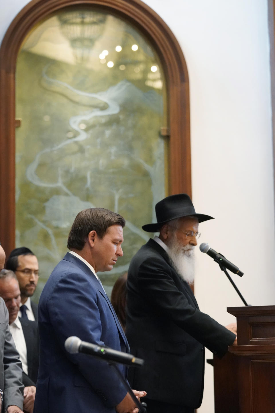 Florida Gov. Ron DeSantis, left, and Rabbi Sholom Lipskar participate in a moment of silence, Monday, June 14, 2021, at the Shul of Bal Harbour, a Jewish community center in Surfside, Fla. DeSantis visited the South Florida temple to denounce anti-Semitism and stand with Israel, while signing a bill into law that would require public schools in his state to set aside moments of silence for children to meditate or pray. (AP Photo/Wilfredo Lee)