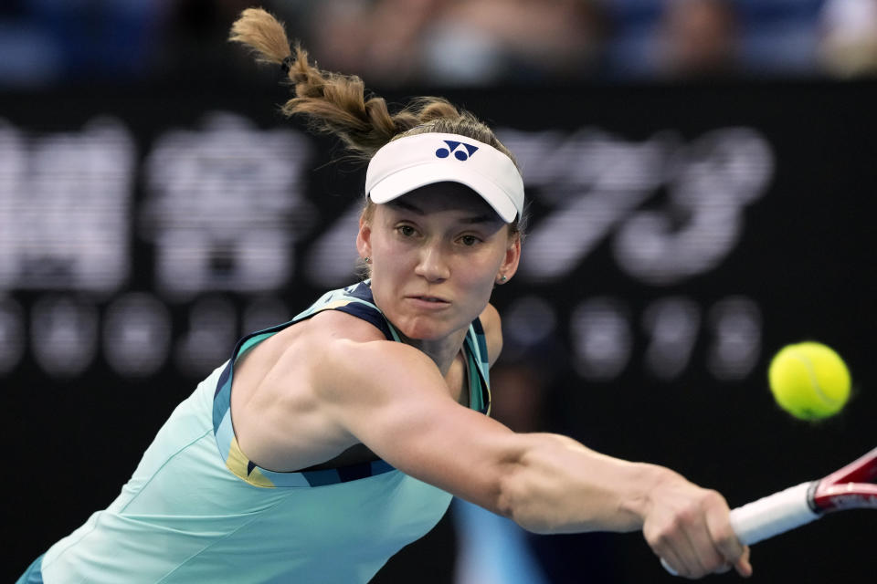 Elena Rybakina of Kazakhstan plays a backhand return to Karolina Pliskova of the Czech Republic during their first round match at the Australian Open tennis championships at Melbourne Park, Melbourne, Australia, Tuesday, Jan. 16, 2024. (AP Photo/Andy Wong)