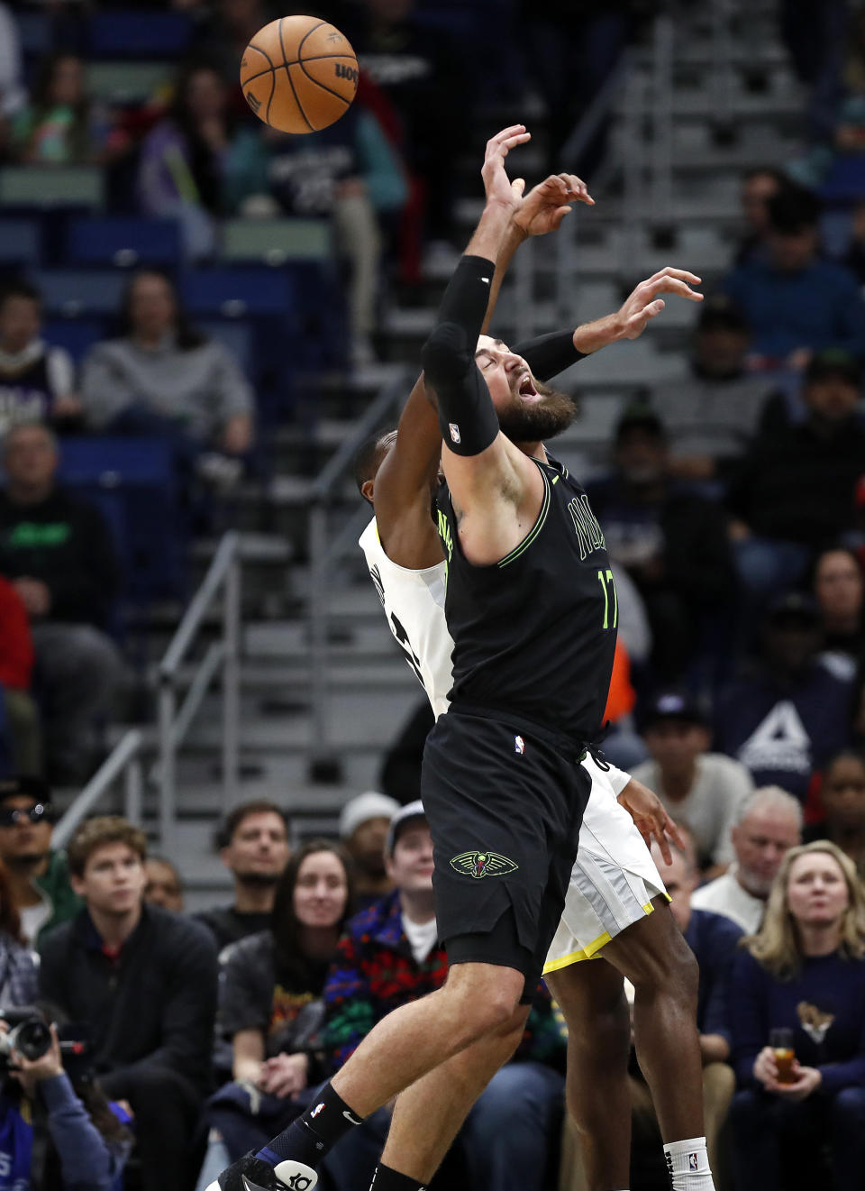 New Orleans Pelicans center Jonas Valanciunas (17) is fouled by Utah Jazz guard Kris Dunn in the first half of an NBA basketball game in New Orleans, Tuesday, Jan. 23, 2024. (AP Photo/Tyler Kaufman)