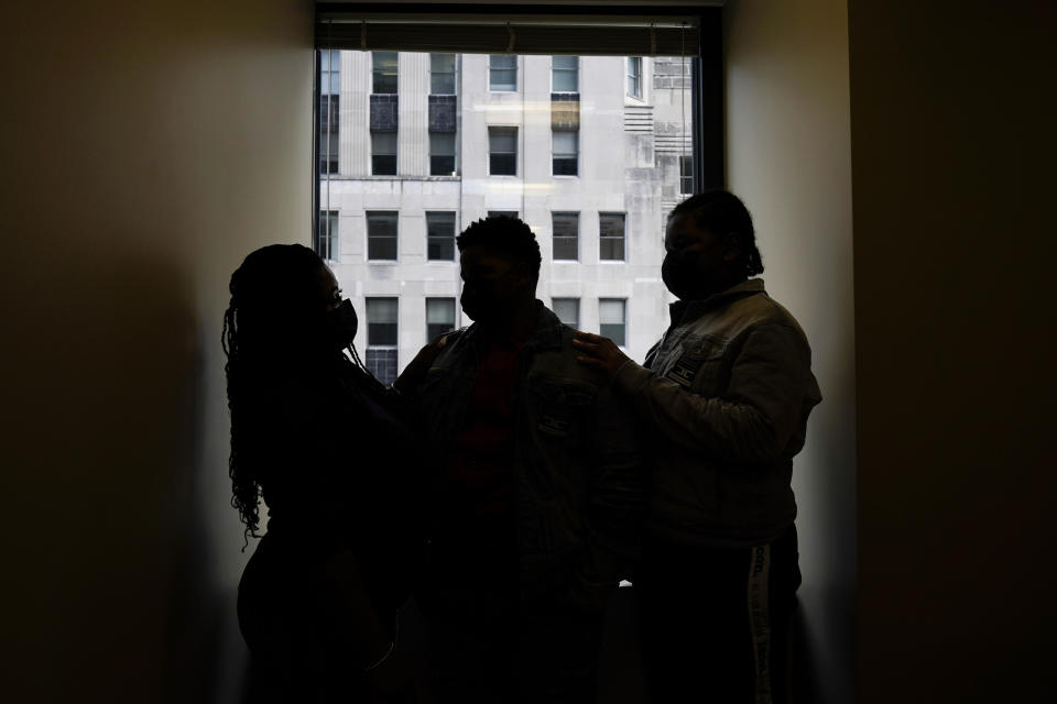 In this Sept. 23, 2021, photo Domonique Wilson, left, poses for a photo with her sons Royal, center, and Roy at her attorneys office in Chicago. Royal Smart was handcuffed by police in south Chicago as part of raid on his home when he was 8 years old. Police were looking for illegal weapons and found none. No one was arrested. Wilson, said her children sleep with the lights on all night. They continue to try therapy, but she said the memories still torment them. (AP Photo/Nam Y. Huh)