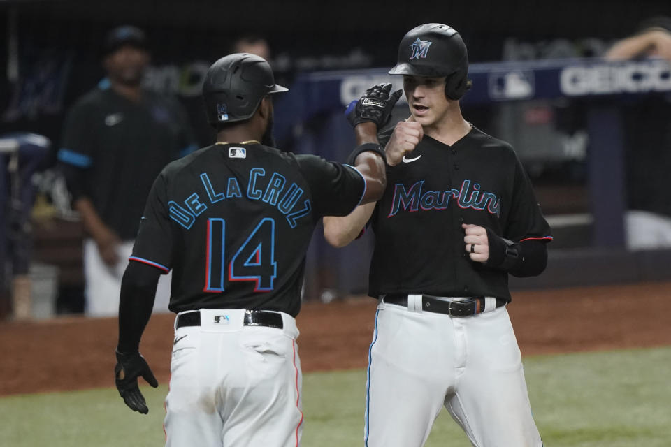 Miami Marlins' Brian Anderson (15) is congratulated by Bryan De La Cruz (14) after scoring during the eighth inning of a baseball game against the Washington Nationals, Friday, Sept. 23, 2022, in Miami. (AP Photo/Marta Lavandier)