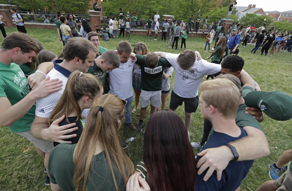 Students pray together during a vigil at the University of North Carolina-Charlotte in Charlotte, N.C., Wednesday, May 1, 2019 after a student with a pistol killed two people and wounded four others on Tuesday. (AP Photo/Chuck Burton)