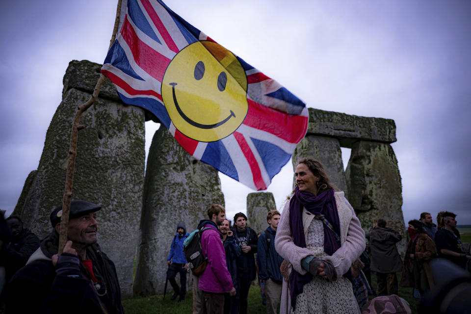 People inside the stone circle during Summer Solstice at Stonehenge, where some people jumped over the fence to enter the stone-circle to watch the sun rise at dawn of the longest day of the year in the UK, in Amesbury, England, Monday June 21, 2021. The prehistoric monument of ancient stones have been officially closed for the celebrations due to the coronavirus lockdown, but groups of people ignored the lockdown to mark the Solstice, watched by low key security. (Ben Birchall/PA via AP)