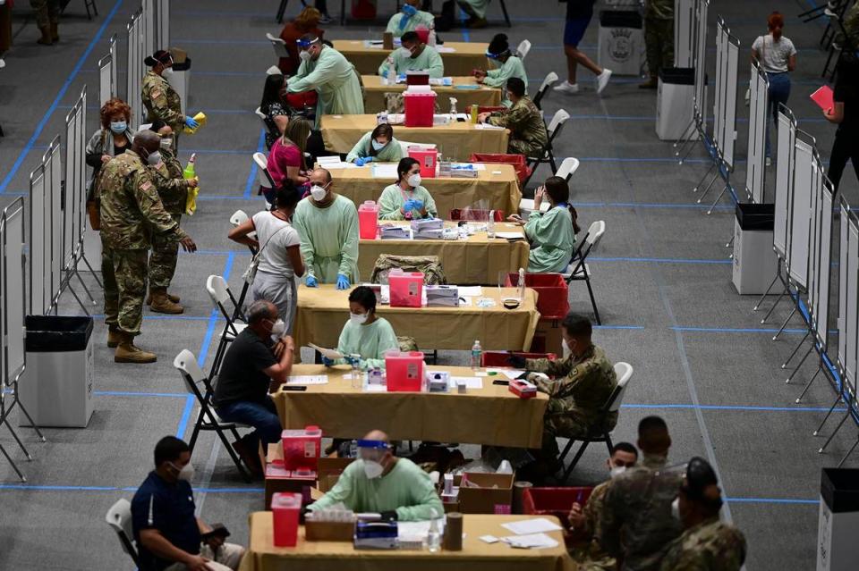 Healthcare workers receive the COVID-19 vaccine at the Pedrín Zorrilla Colliseum in San Juan, Puerto Rico, on Dec. 30, 2020.