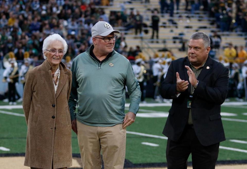 Virginia Madden, wife of the late John Madden, and her son Mike Madden attended Cal Poly’s football game on Saturday, Oct. 1, 2022, to announce plans for the John Madden Football Center. The Hall of Fame coach and broadcaster was a Cal Poly alum. Don Oberhelman, Cal Poly athletic director, claps at right.