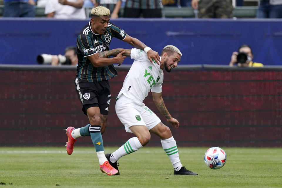 Los Angeles Galaxy defender Julian Araujo, left, and Austin FC forward Diego Fagundez battle for the ball during the first half of a Major League Soccer match Saturday, May 15, 2021, in Carson, Calif. (AP Photo/Mark J. Terrill)