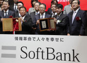 SoftBank Corp.'s CEO Ken Miyauchi, center, poses for a photo with other executives during a ceremony at the Tokyo Stock Exchange in Tokyo Wednesday, Dec. 19, 2018. SoftBank Group Corp.'s Japanese mobile subsidiary began trading on the Tokyo Stock Exchange on Wednesday in one of the world's biggest share offerings.(AP Photo/Koji Sasahara)