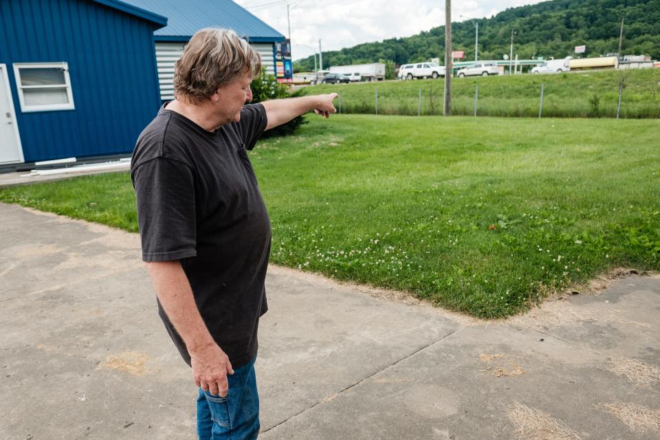 Gardner Street Garage owner John Fockler points towards the creek that he says periodically floods in rain storm, causing access issues on his property, Tuesday, June, 4 in Uhrichsville.