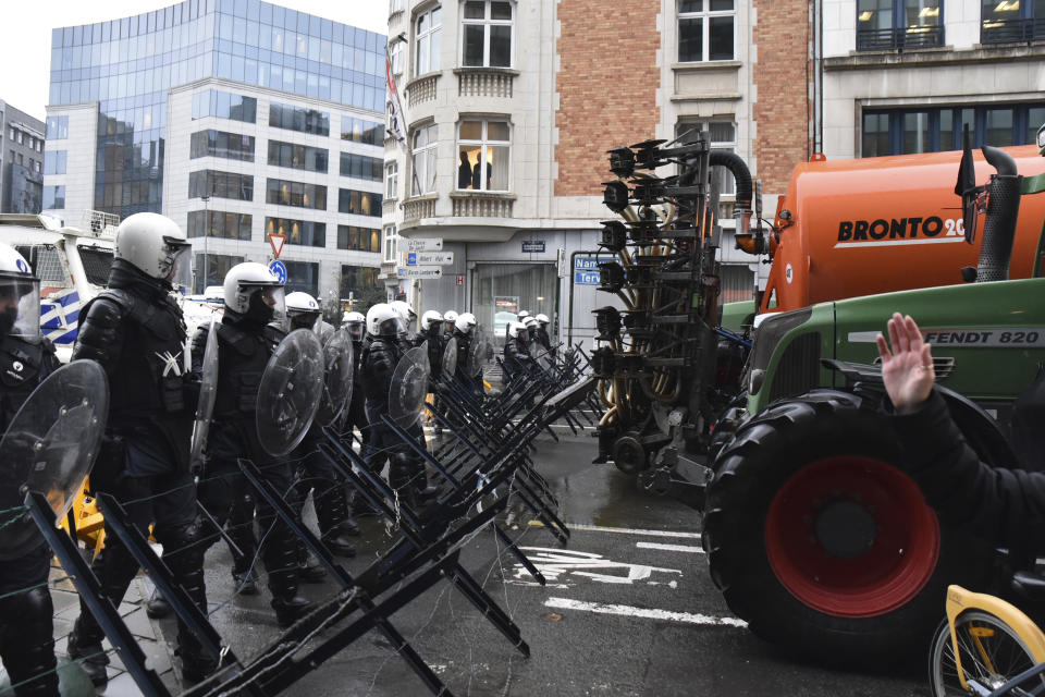 Police stand behind a barricade during a protest of farmers in the European Quarter outside a meeting of EU agriculture ministers in Brussels, Monday, Feb. 26, 2024. European Union agriculture ministers meet in Brussels Monday to discuss rapid and structural responses to the crisis situation facing the agricultural sector. (AP Photo/Harry Nakos)