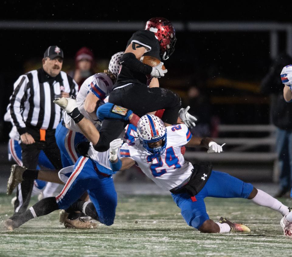 Chardon's Sean Carr hurdles West Holmes defenders.