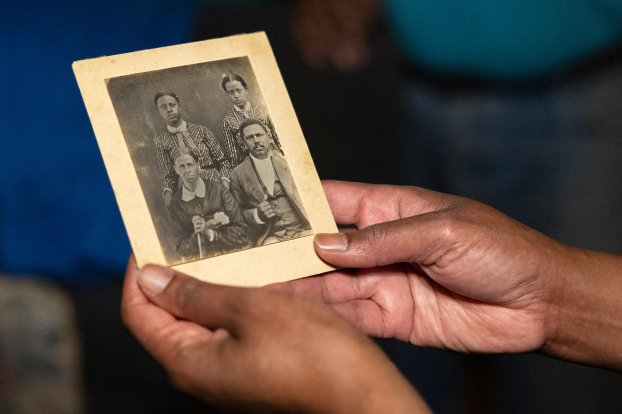 Lacretia holds a picture of her forebears: Amy Guthrie Craig and Amy husband, Tapp Craig, seated, and two of their daughters.   (Kevin Wrum / Reuters)