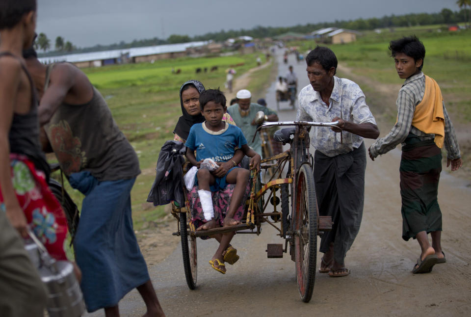 In this Sept. 17, 2013 photo, a Muslim man pushes a rickshaw with an injured child, all became displaced following the 2012 sectarian violence, close to Bawda Pa IDP camp in Rakhine state, Myanmar. President Thein Sein traveled to Myanmar's conflict-torn west on Tuesday, Oct. 1, 2013 as a new spate of sectarian violence gripped the state of Rakhine, with police saying Buddhist rioters killed a 94-year-old Muslim woman and torched more than 70 homes. (AP Photo/Gemunu Amarasinghe)