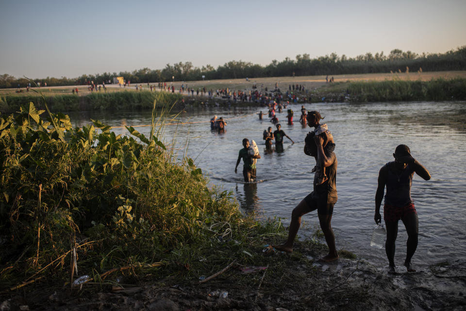 Migrants, many from Haiti, wade across the Rio Grande river from Del Rio, Texas, to return to Ciudad Acuña, Mexico, Monday, Sept. 20, 2021, to avoid deportation from the U.S. The U.S. is flying Haitians camped in a Texas border town back to their homeland and blocking others from crossing the border from Mexico. (AP Photo/Felix Marquez)